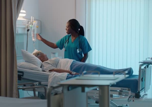 22 Hospital bed, senior patient and nurse talk with medical check and healthcare monitor in ICU. Elderly, person and working on health, wellness and care for surgery and clinic consulting and nursing
